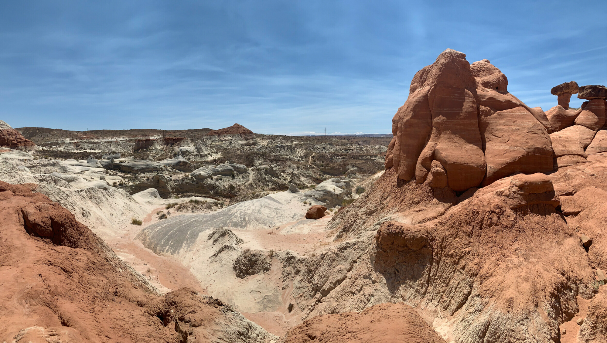 Panoramic view of Toadstool Hoodoos under a clear blue sky, showcasing eroded red rock formations in Kanab, Utah.