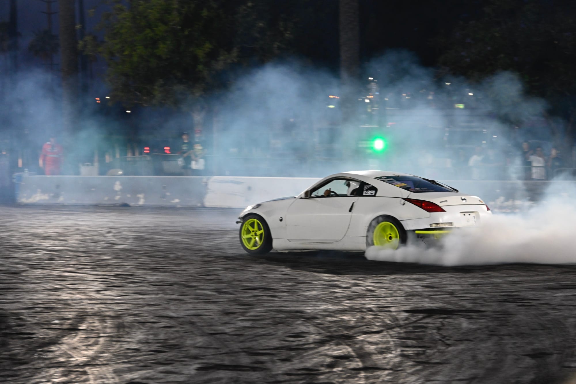 White car drifting with green rims at Drift Night in Irwindale Speedway, LA.