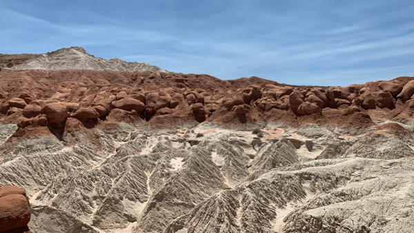 The Toadstool Hoodoos in Utah, showcasing a landscape of contrasting white and red rock formations under a clear blue sky.